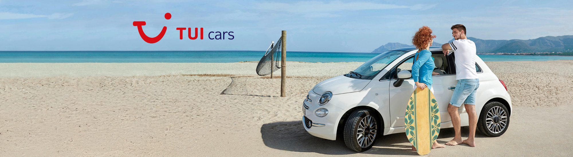 Paar steht barfuß am Strand neben einem weißen Mietwagen. Die Frau hält ein Surfbrett. Im Hintergrund das Meer, ein Volleyballnetz und Berge. Oben links steht das Logo von TUI Cars.