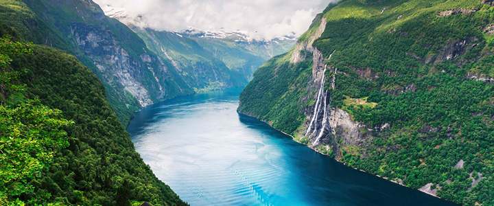 Hochseekreuzfahrt mit MSC Euribia. Atemberaubende Landschaft im Nordland. Tiefblauer Fyord umgeben von grünen Hügeln.