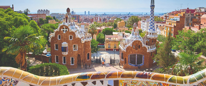 Park Güell, Barcelona; Blick auf zwei charakteristische Gebäude bei Sonnenschein.