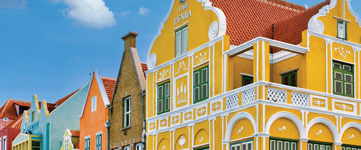 Aneinandergereihte, bunte und farbenfrohe Gebäude mit auffälligen Verzierungen im Fokus.