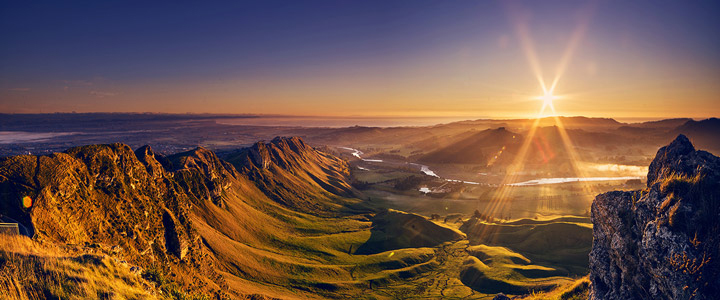 Grenzenlose Naturschönheit: Blick von oben über die Berge und unberührte Natur Neuseelands im Sonnenaufgang.