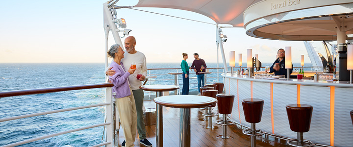 Die Lanai Bar am Heck eines AIDA-Kreuzfahrtschiffs bietet einen offenen Blick aufs Meer. Helle Sitzplätze und eine moderne Gestaltung prägen den Außenbereich.