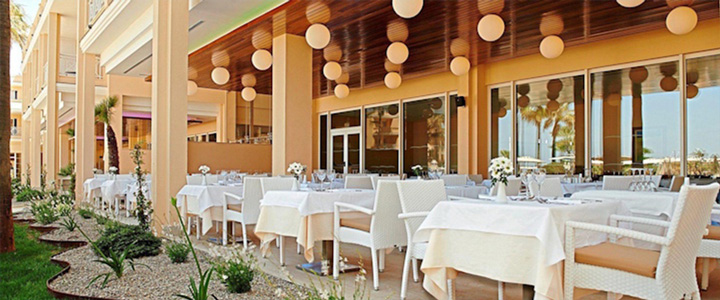 Der helle, stilvoll gestaltete Außenbereich des Hotels bietet gemütliche Sitzplätze und eine entspannte Atmosphäre. Helle Farben und harmonische Gestaltung laden zum Verweilen ein.