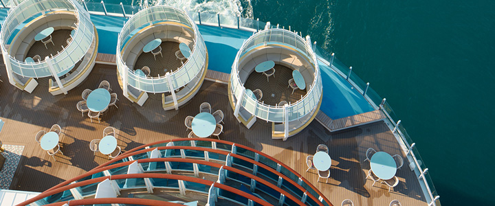 Das Sonnendeck am Heck der Costa Smeralda bietet großzügige Liegeflächen und einen Pool. Das offene Deck ermöglicht weite Blicke auf das Meer.
